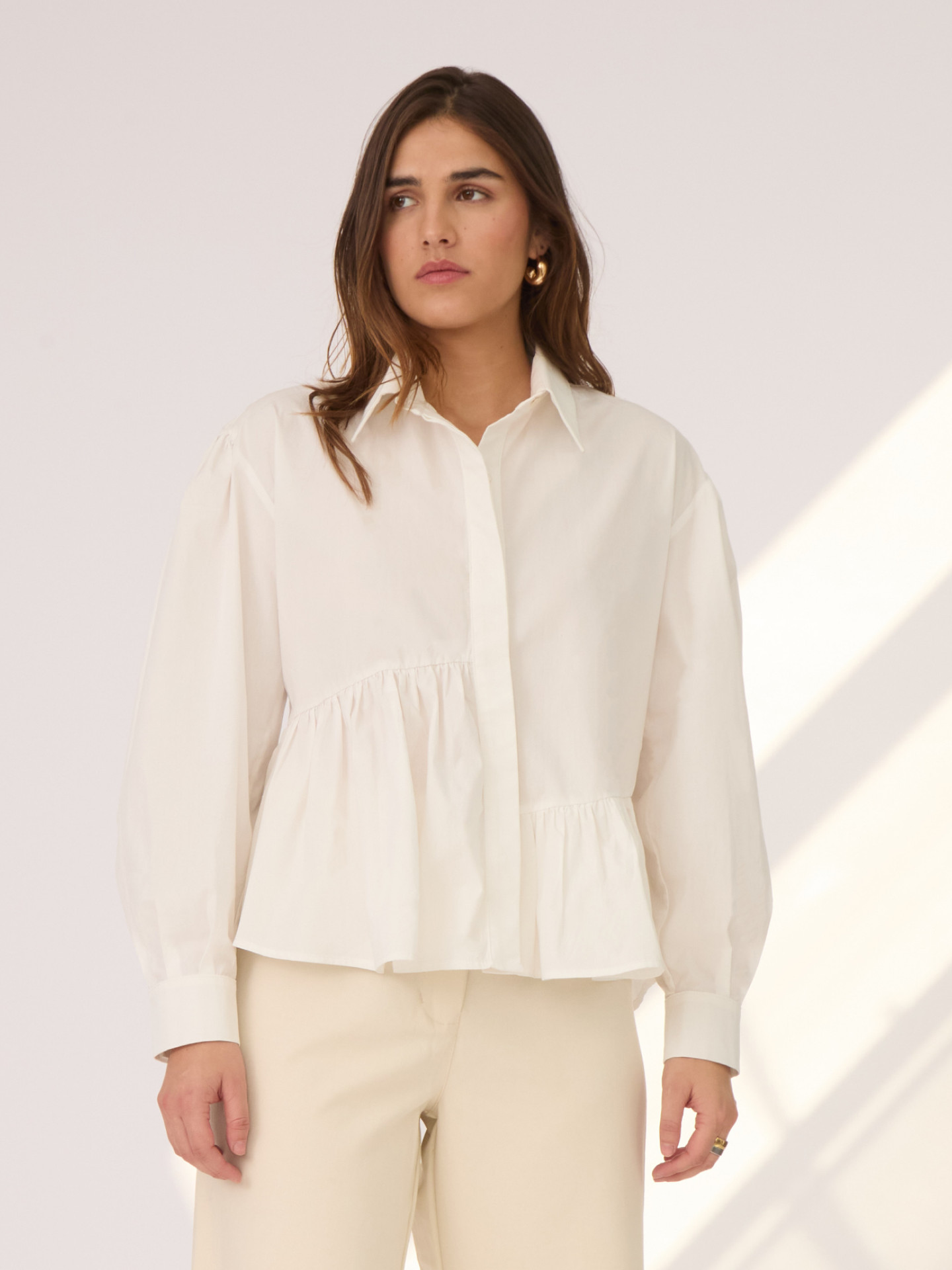 La Camisa Olivia tiene un corte asimétrico, mangas globo y un largo ideal para combinar con diferentes estilos de pantalones y faldas. Esta camisa es la definición de versátil.