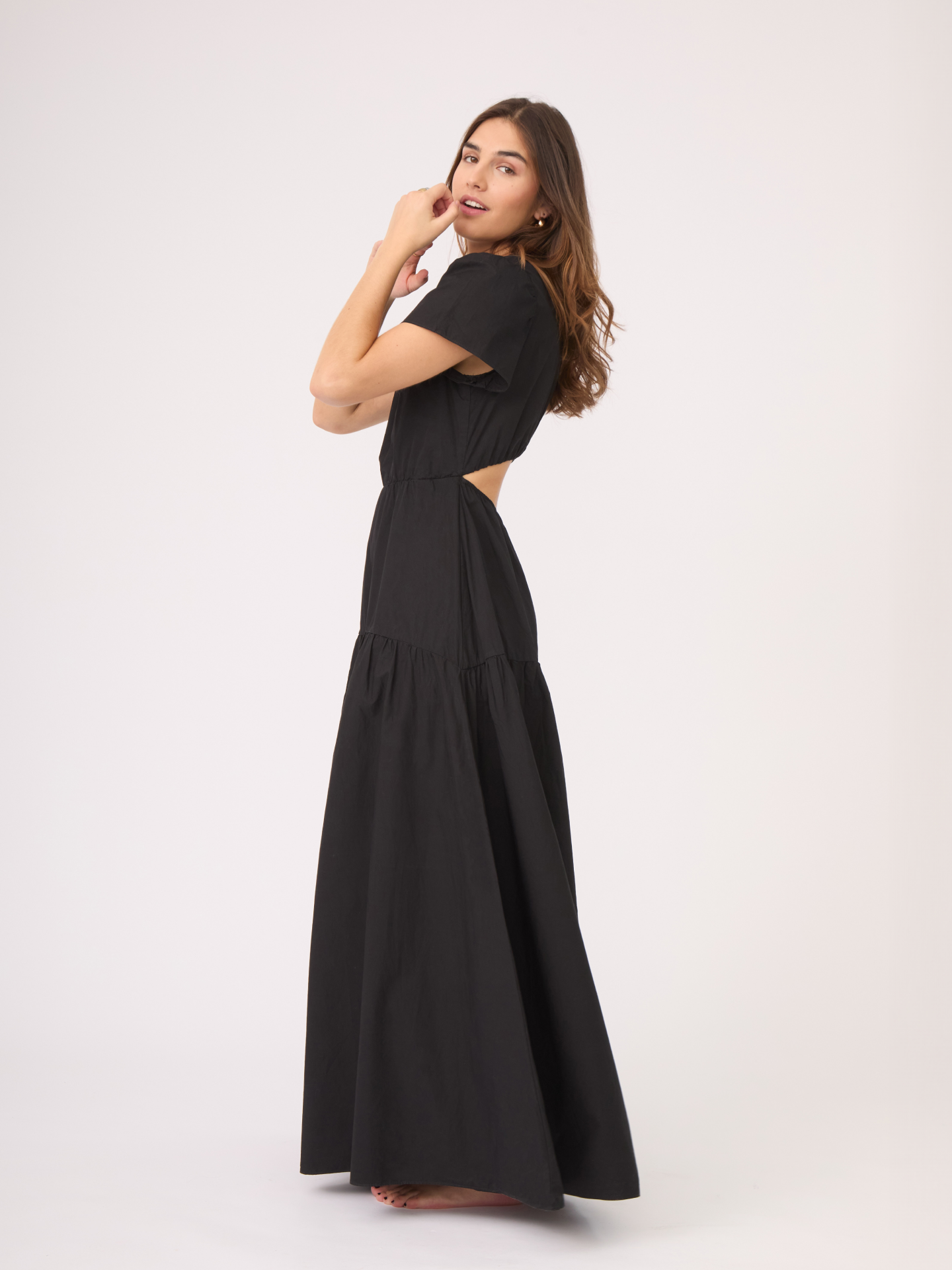 El vestido negro tiene manga corta y una sutil apertura en la espalda, volviéndolo ideal para clima caliente o frío.