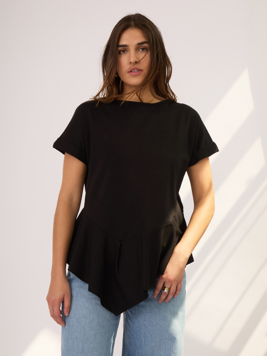 La Camiseta negra tiene una silueta de cuello bandeja, corte asimétrico y fit ajustado. Su largo es ideal para combinar con cualquier pantalón y estilizar la figura. El color negro aporta versatilidad para usarla de día o de noche.