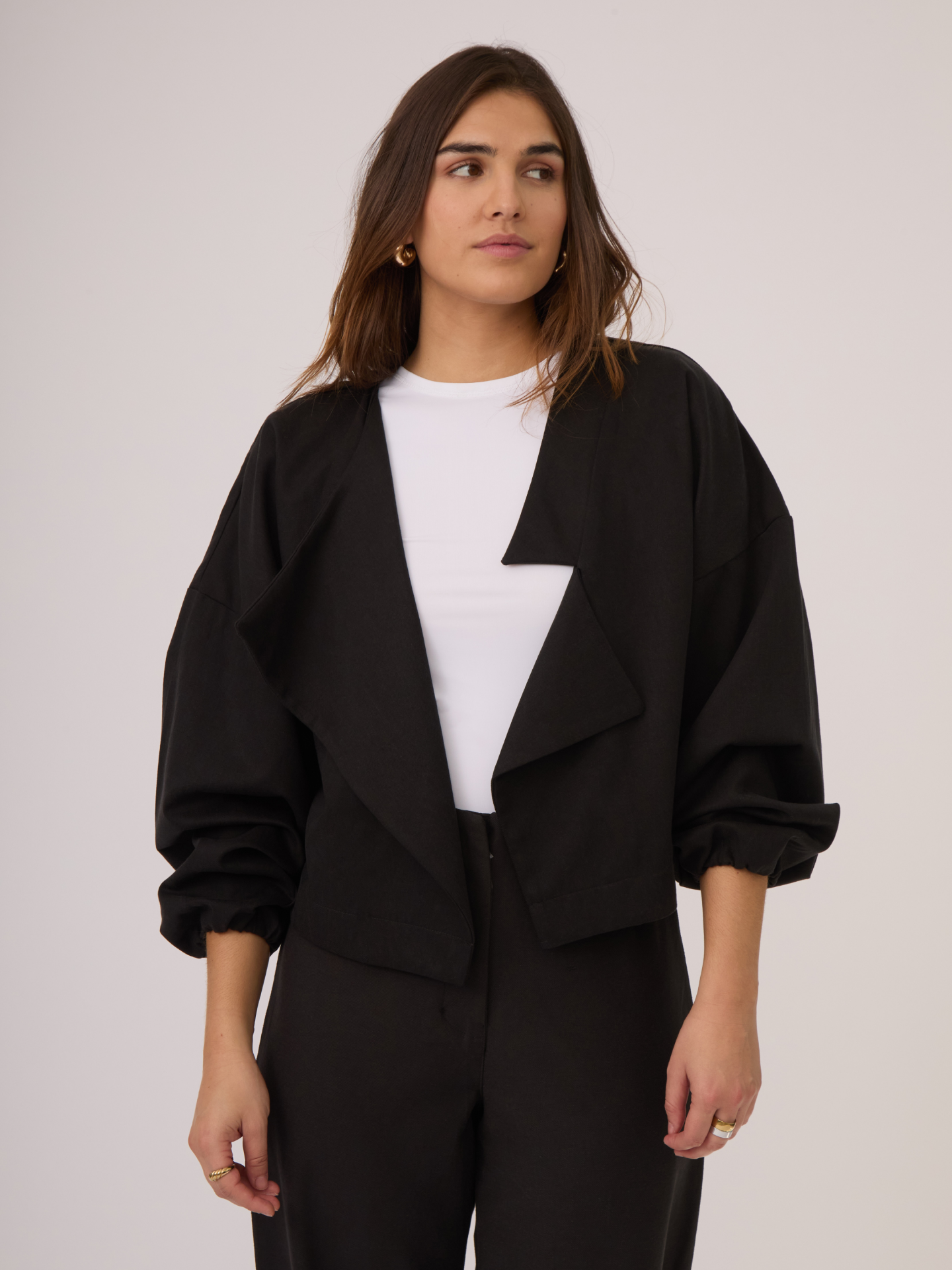 Chaqueta negra con corte asimétrico, mangas globo y fit oversized. Su material es perfecto para climas templados y cambios de estación.